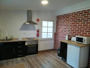 Kitchen area with oven, microwave, and stainless steel range hood.