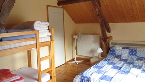 Un dormitorio con literas, un radiador, una lámpara y una puerta.