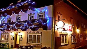 A building with a balcony, multiple windows, and outdoor seating. - Inntalhof Pension (Raubling)