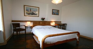 Cozy retreat with a central bed, wall-mounted lamps, and elegant artwork.