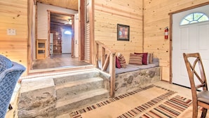 A wooden interior with a stone staircase leading to a door, a bench with cushions, and a fire extinguisher on the wall. - Updated Cabin w/ Porch, Mins to Cossatot River (Wickes)