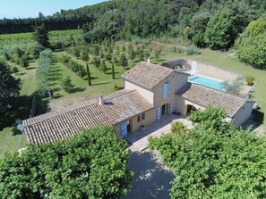 A villa with a tiled roof, a swimming pool, and a well-maintained garden.