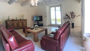 Ein Wohnzimmer mit Ledersofas, einem Holztisch, einem Fernseher und einem Schrank.