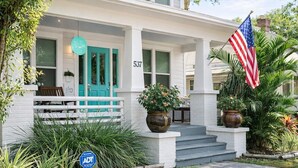 Ein Haus mit Veranda, einer türkisblauen Tür, einer amerikanischen Flagge und einem Schild mit der Nummer 537.