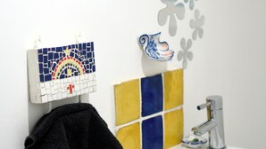 A bathroom with a white sink, a towel rack, decorative tiles, and a mirror. - Studio, garden, jacuzzi, sauna, yoga, massages (Soorts-Hossegor)