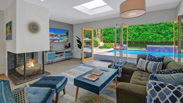 En moderne stue med pejs, pool og sofa.