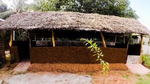 A rustic hut with a thatched roof, a brick base, and a small entrance. - Sunwon Holiday Home (Dambulla)