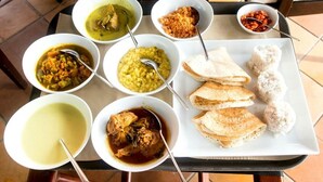 A table with various dishes including curries, rice, and flatbreads, suggesting a meal setting. - Sunwon Holiday Home (Dambulla)