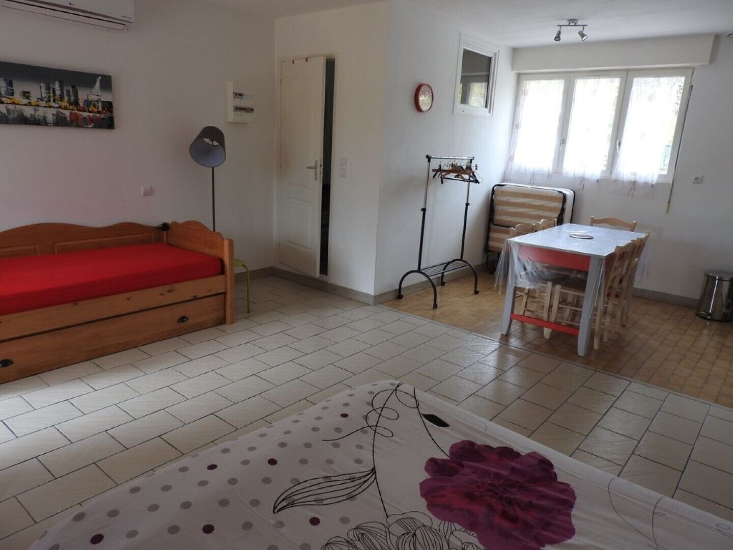 A small, clean room with a bed, a table, and a chair.