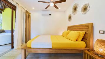 A bedroom with a wooden bed, yellow bedding, a ceiling fan, and decorative wall art.