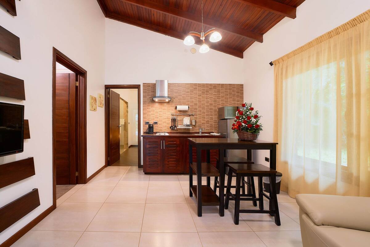 A modern kitchen with wooden cabinets, a dining table, and a built-in oven.