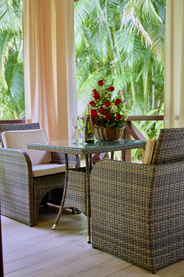 Un conjunto de sofá y mesa de mimbre en una habitación con vista a palmeras.