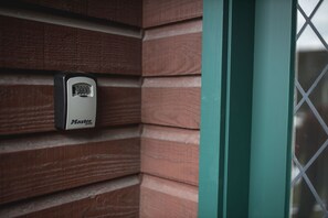 A security keypad mounted on a wooden wall. - 66 Robins Road (Queenstown)