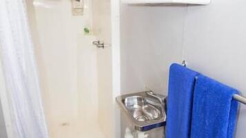 Ein Badezimmer mit Dusche, Waschbecken und Spiegel.
