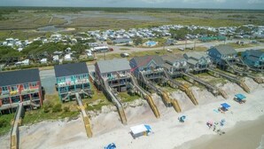 Eine Küstenlandschaft mit Strandhäusern, die durch Holzstege verbunden sind.