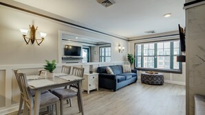 Una sala moderna con comedor, un sofá y un televisor.