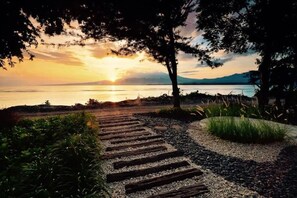 A pathway leading to a lake with a sunset in the background. - Cabana (Gili Air)