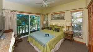 A bedroom with a bed, a desk, a chair, a TV, and a balcony. - 2903 Avenue F 3 Bedroom Home by RedAwning (Holmes Beach)