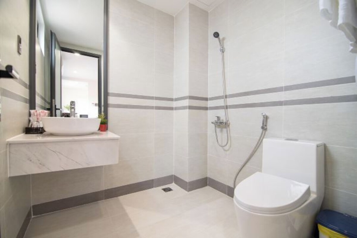 Un baño moderno con lavamanos blanco, inodoro y ducha.