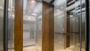 A modern elevator with wooden panels and glass doors. - Bin Bin Hotel 7 - Near Ton Duc Thang University (Ho Chi Minh City)