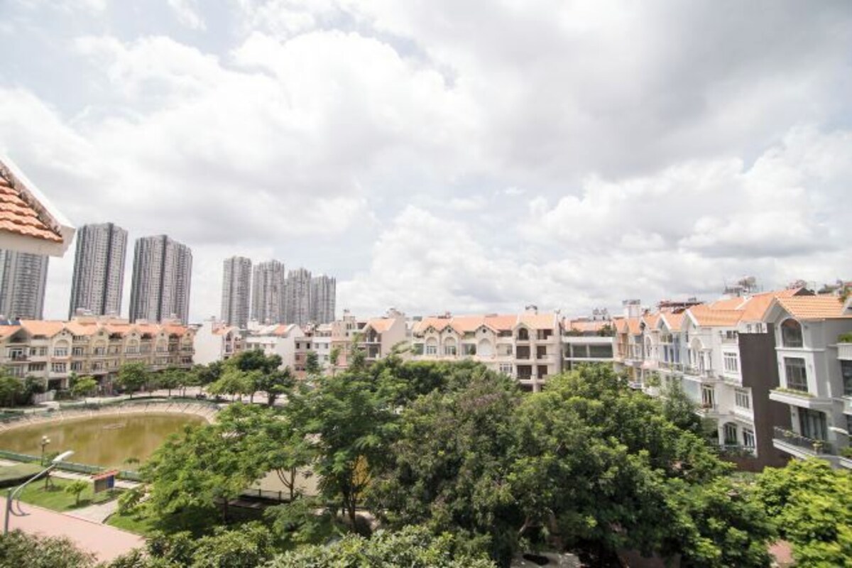 Zona residencial con edificios altos, un parque con un estanque y diversos edificios de apartamentos.