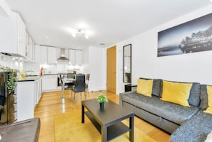 A modern apartment with a kitchen, dining area, and living room.