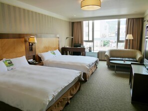 A hotel room with two beds, a desk, a sofa, and a TV. - Gueylin Hotel (Taoyuan City)