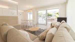A modern living room with a sofa, a zebra-patterned rug, and a dining area with a table and chairs. - Brunet I | The Rentals Collection (San Sebastián)