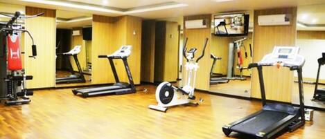 A gym with treadmills, an elliptical, and a stationary bike.