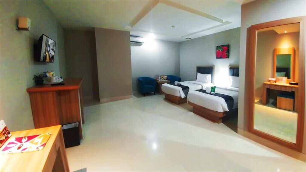 Una habitación de hotel con cama, mesita de noche, silla y escritorio con silla.