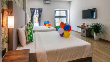 A hotel room with two beds, a TV, a plant, and a window with curtains.