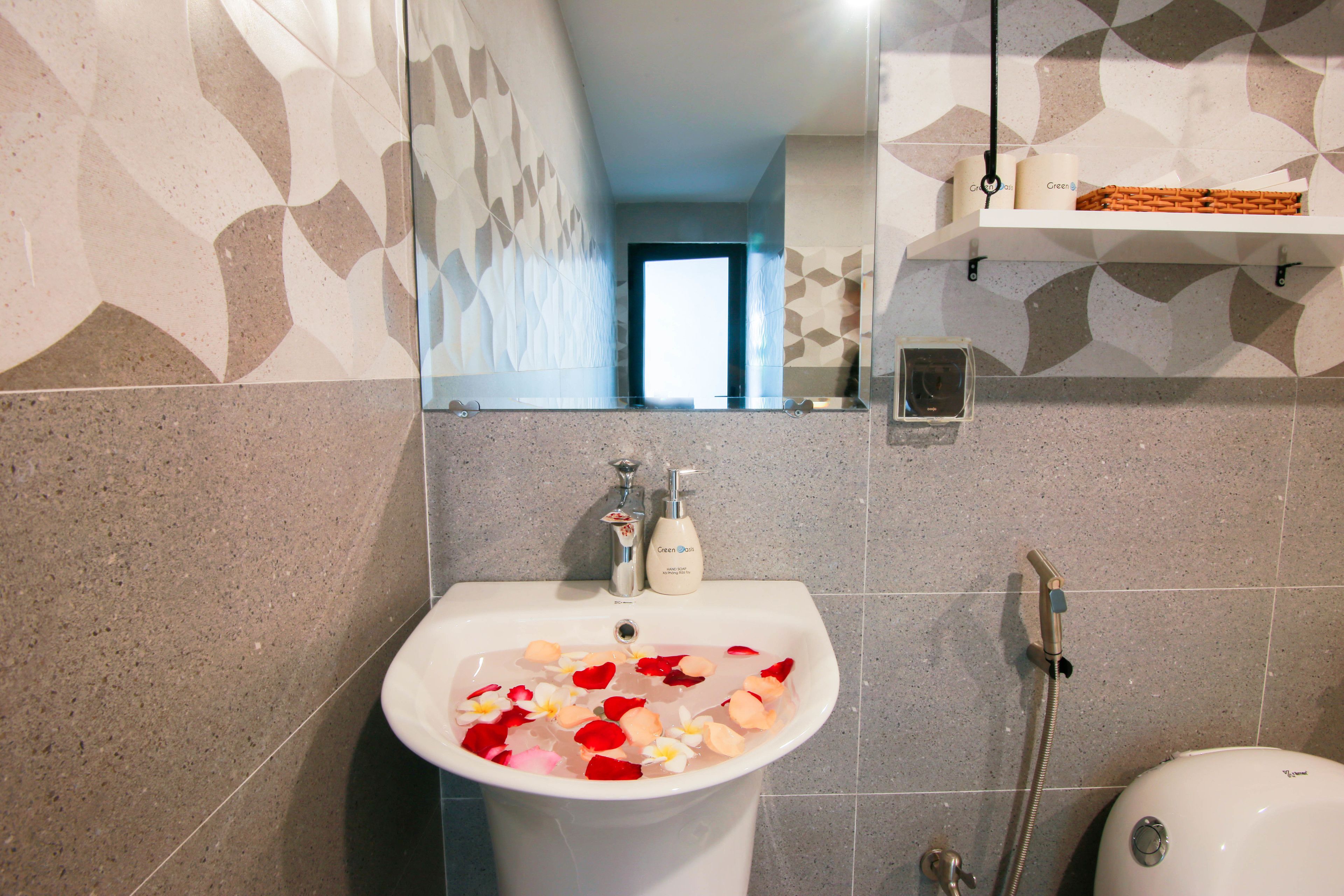 Un baño con lavabo, ducha y espejo.