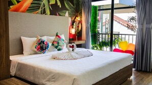 Una cama bien tendida con sábanas blancas, un cojín con forma de corazón y un cojín con forma de cisne.