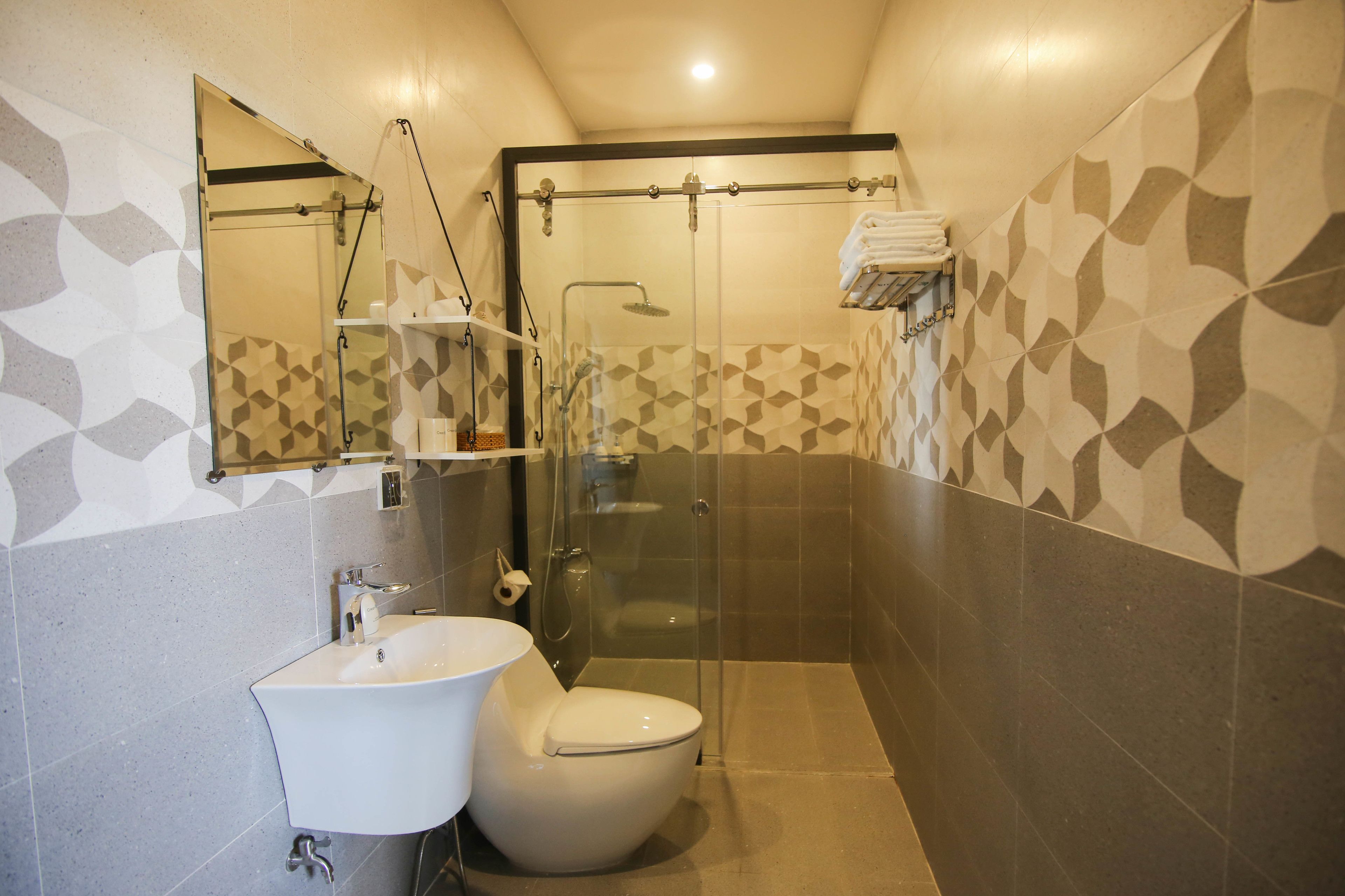 A modern bathroom with a glass-enclosed shower, a sink, and a toilet.