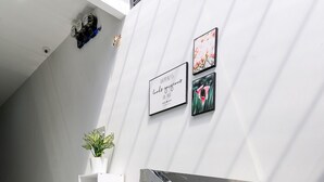 Un interior moderno con una escalera de cristal, paredes blancas y decoración minimalista.
