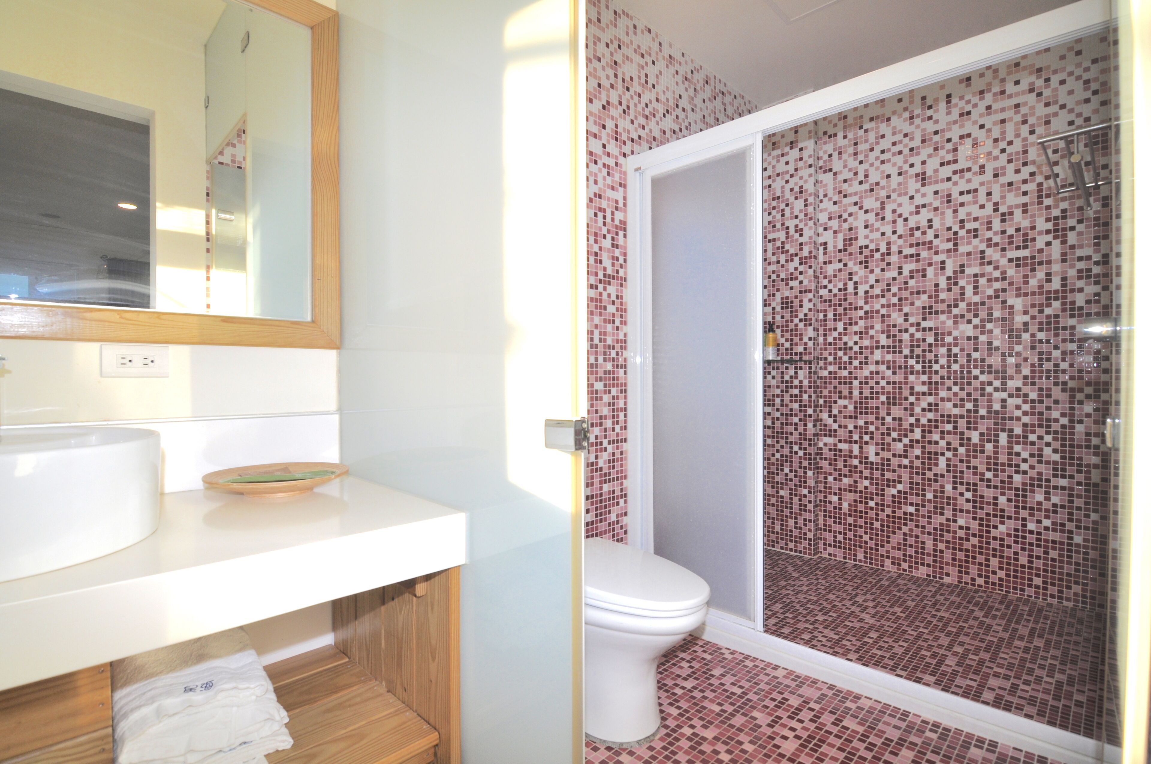 A bathroom with a white sink, mirror, and toilet.