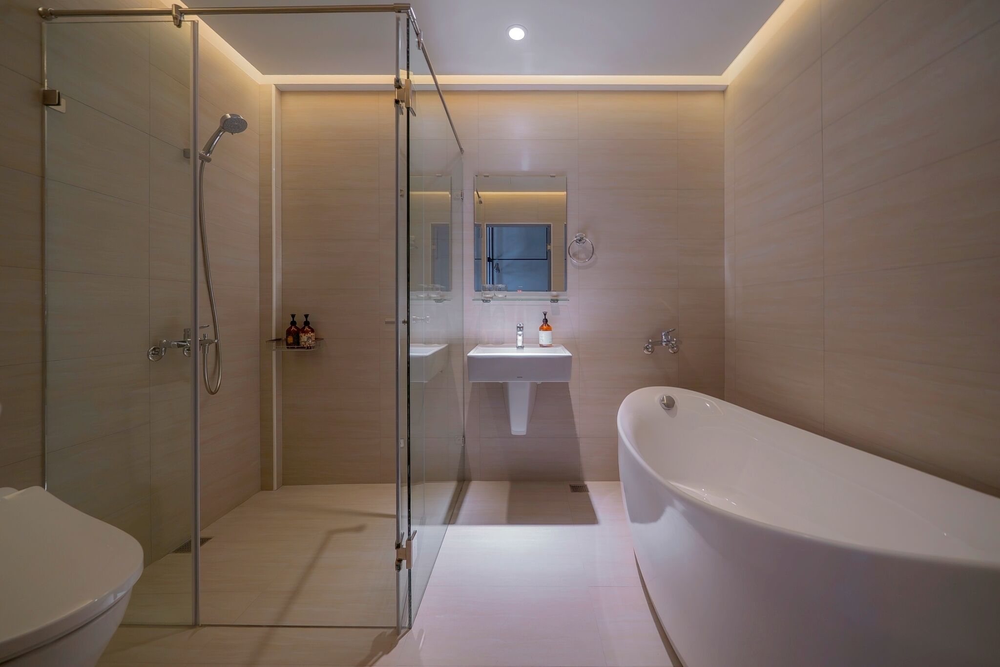 A modern bathroom with a glass-enclosed shower, a freestanding bathtub, and a sink with a mirror above it.