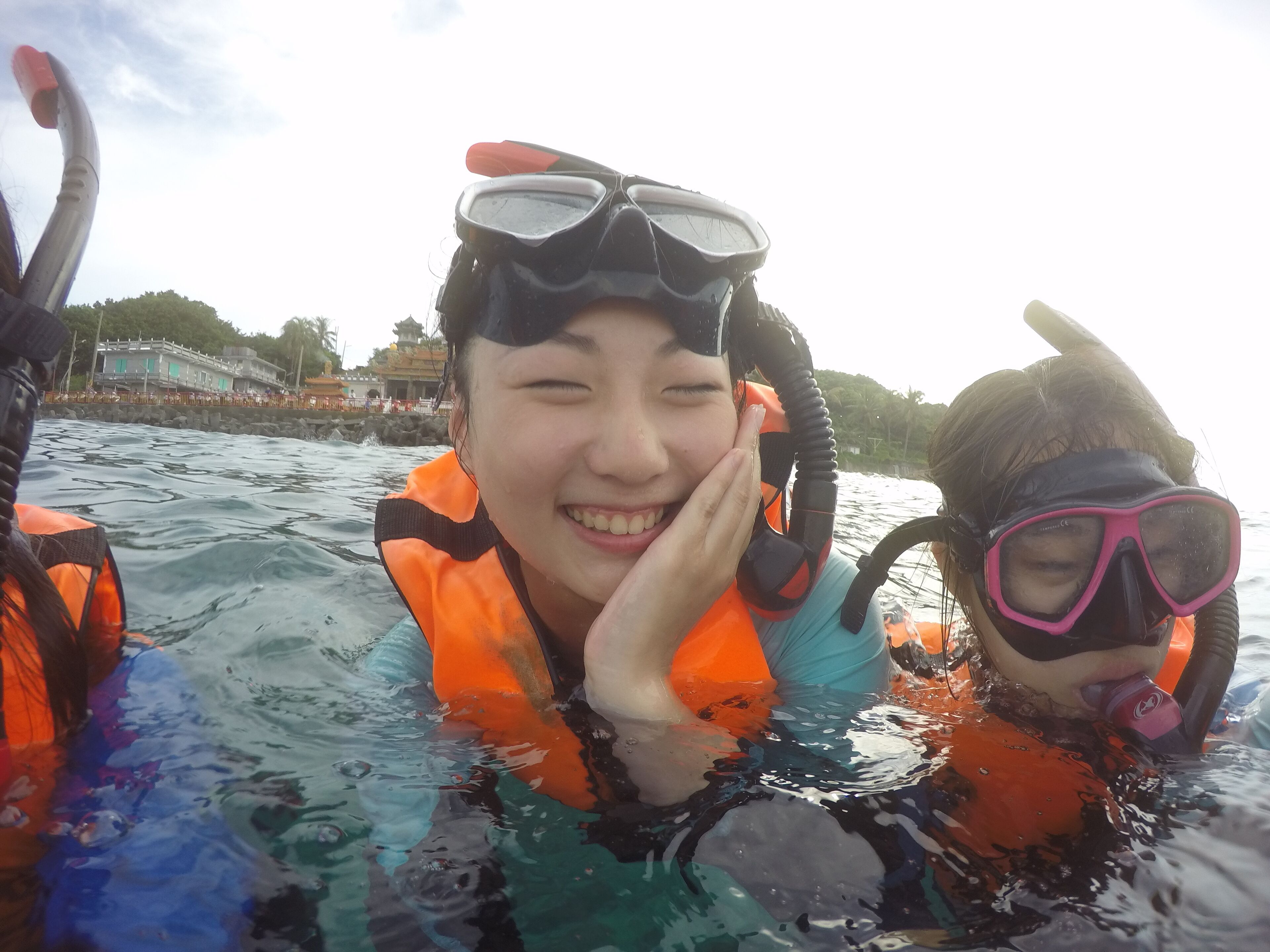 Two people in a body of water wearing snorkeling gear.