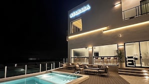 A modern building with a pool area, outdoor seating, and a visible bar area. - Star Sea B&B (Liuqiu)