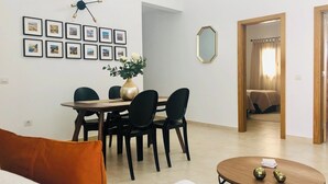 Un salon moderne comprenant un coin repas, une table basse ronde et un grand miroir mural.