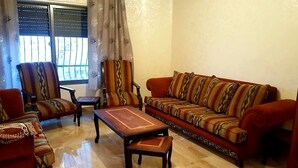 A living room with a sofa, armchairs, a coffee table, and a patterned rug. - Private Family Apartment - Very Quiet Location (Amman)