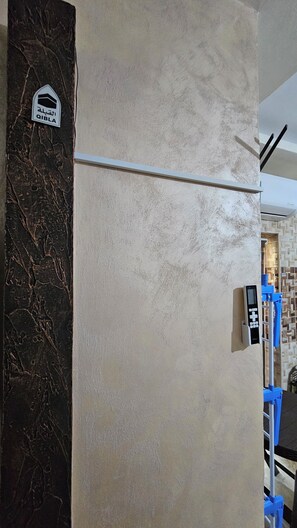A wall with a textured surface and a door with a sign. - Private Family Apartment - Very Quiet Location (Amman)