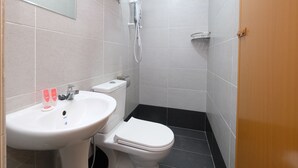 Un baño con lavamanos, inodoro y toallero.