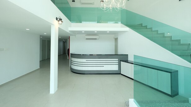 Un interior moderno con un mostrador de recepción, una escalera y una araña.