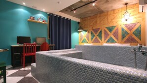 A room with a checkered floor, a desk with a computer, a red chair, and a bed with a textured headboard. - Hotel Yaja Suwon City Hall (Suwon)