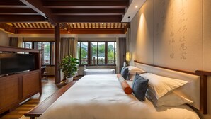 A hotel room with a large bed, a TV, a balcony, and a wall with calligraphy. - SSAW Boutique Hotel Nanjing Qifeng Confucius House (Nanjing)