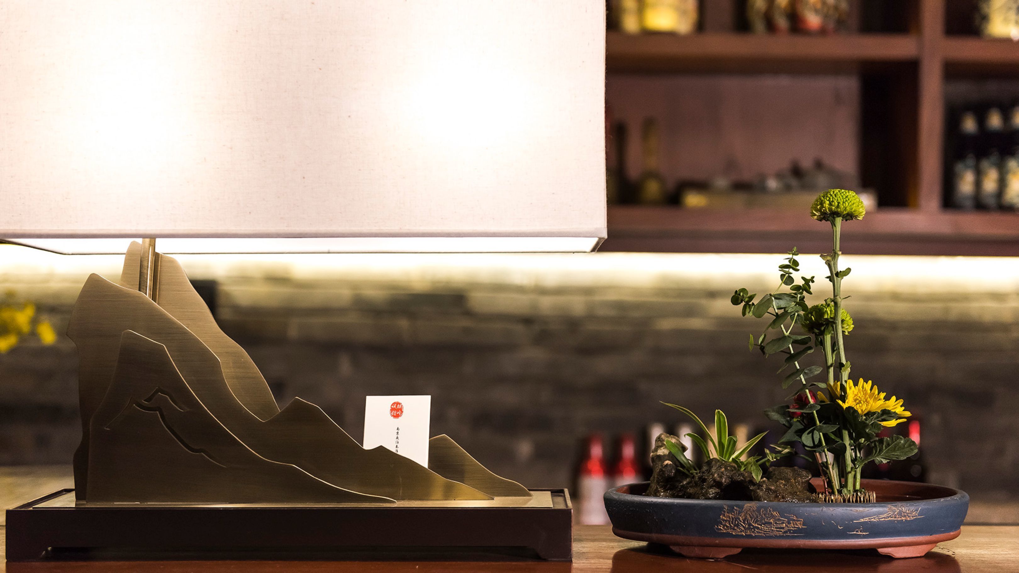 A table with a metal sculpture and a potted plant.