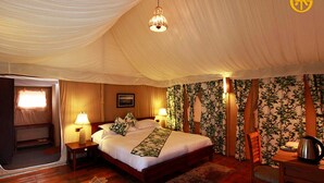 A tent-style bedroom with a bed, two bedside lamps, a wooden chair, and a table with a kettle. - Queens Meadows by Sunshine & Smiles (Ranikhet)