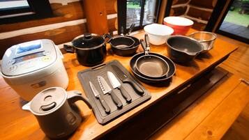A kitchen counter with various cooking utensils, a rice cooker, and a coffee maker.