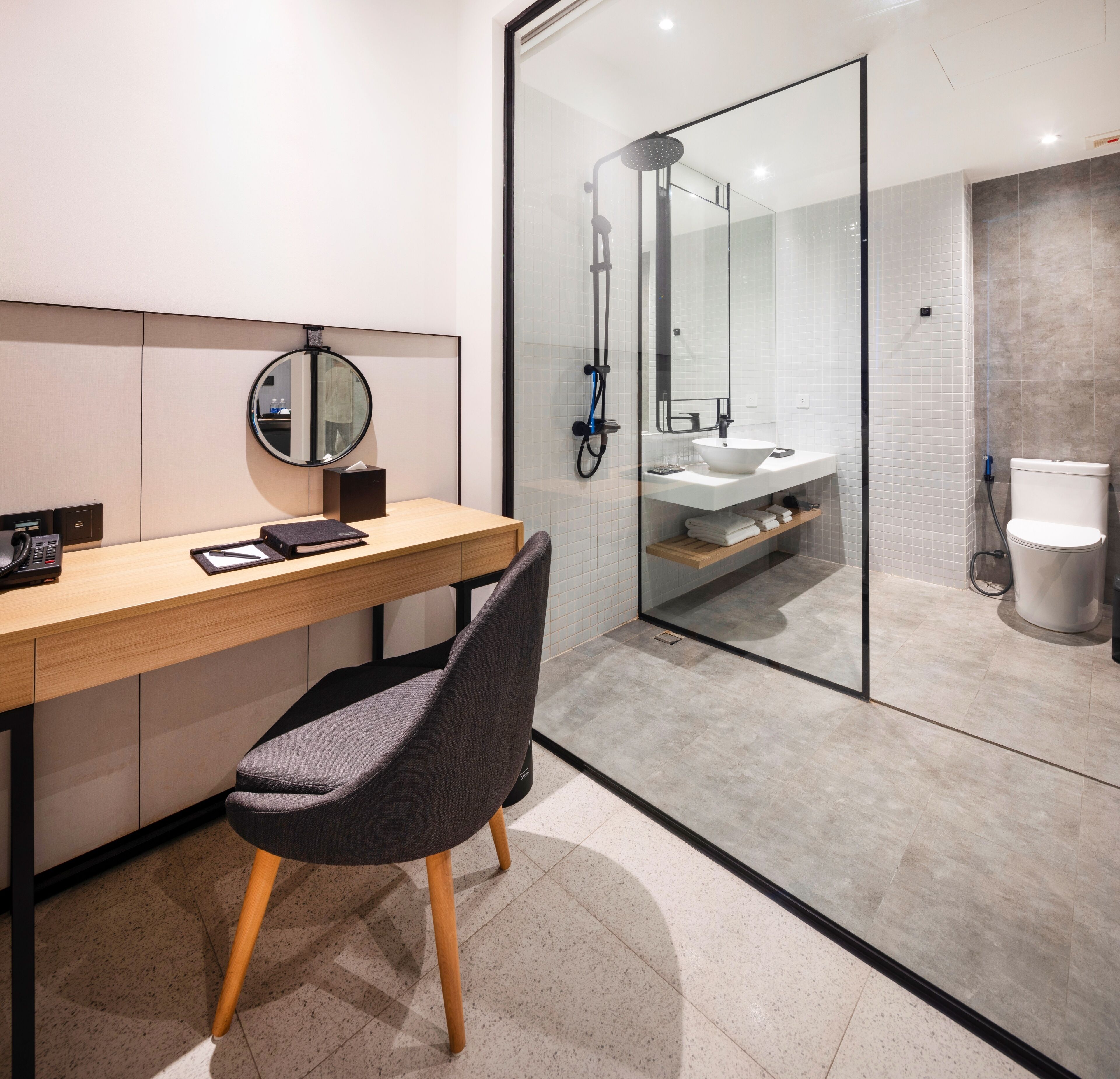A modern bathroom with a glass shower enclosure, a sink, and a toilet.